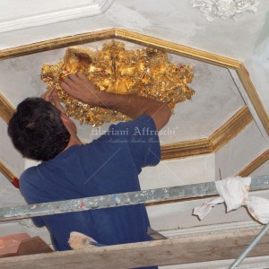 Gold leaf decoration of coffered ceiling with stuccoes. Private villa in Italy